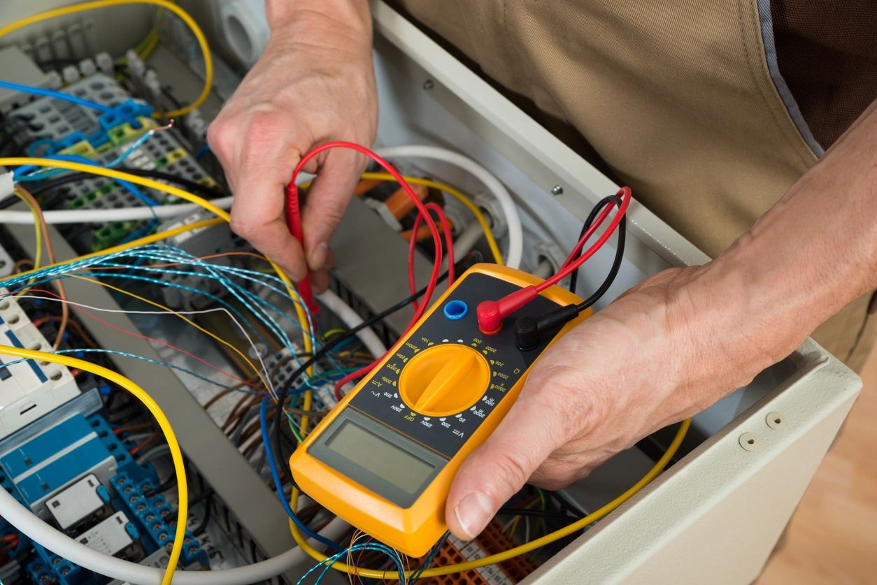 Electrician testing electrical panel with multimeter